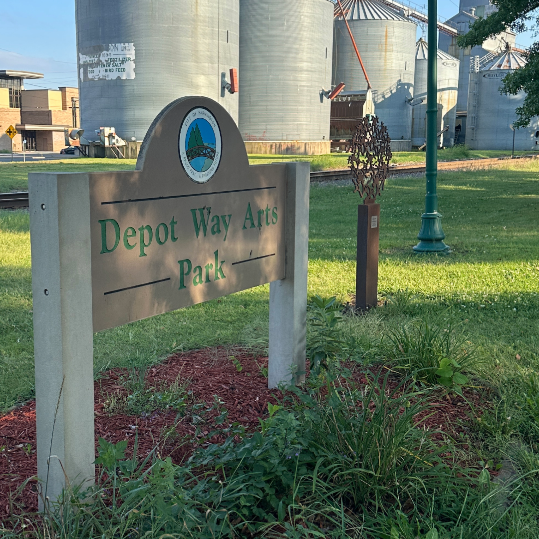 Depot Way Arts Park sign with grain elevators in the background