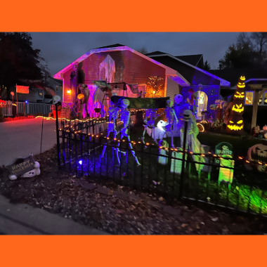Halloween Havoc Tour image of a house decorated at night for Halloween with lights and inflatables